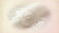 Delicate white lace trim with floral patterns on soft pastel background for wedding invitations bridal accessories feminine design projects.