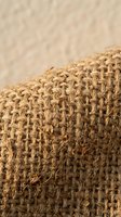 Natural burlap fabric texture with woven jute fibers in close-up macro detail showing rustic organic material for eco-friendly sustainable design projects.