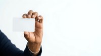 Close-up of male hand with medium skin tone holding blank white card against neutral background, suitable for business, marketing, and promotional design projects.