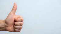 Male hand showing thumbs up gesture on white background for approval, success and positive feedback concepts.