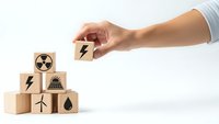 Hand placing wooden cube with lightning bolt symbol completing energy source pyramid on white background for sustainable power concepts.