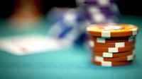 Casino poker chips stacked on green felt gaming table with blurred background creating bokeh effect for gambling and entertainment concepts.