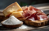 Traditional Italian antipasto with aged parmesan cheese, thinly sliced prosciutto ham, and sea salt on rustic wooden board, perfect for gourmet appetizers.