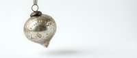 Vintage silver Christmas ornament with intricate patterns hanging against white background, perfect for holiday decorations and festive designs.