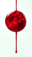 Red liquid sphere with marbled texture dripping on white background. Abstract fluid art concept for creative projects and modern design applications.