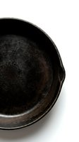 Vintage cast iron skillet with seasoned cooking surface isolated on white background for culinary and kitchen design projects.