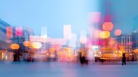 Abstract urban nightlife scene with blurred motion people silhouettes walking in city center against illuminated buildings and colorful bokeh lights creating dreamy atmosphere.