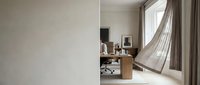 Modern minimalist home office with natural light from large window, wooden desk, neutral curtains, and clean white walls for contemporary workspace design.