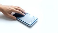 Hand of a young Asian man touching smartphone screen on white background, mobile technology and communication concept.