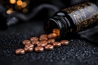 Brown coffee beans spilling from dark vintage bottle on black textured background with bokeh lights, creating luxurious mood for coffee shop marketing and branding.