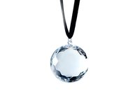 Crystal ball pendant on black cord against white background, faceted round glass ornament with reflective surface creates elegant jewelry piece.