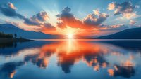 Majestic sunset over calm mountain lake with dramatic sky and sunbeams reflecting on water surface creating mirror effect between mountains.