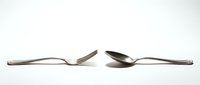 Modern stainless steel fork and spoon set with sleek curved handles isolated on white background for kitchen and dining design projects.
