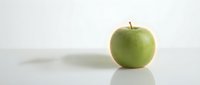 Fresh green apple isolated on white background with natural shadow, suitable for healthy eating, nutrition, and food-related design projects.