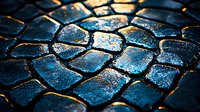 Wet cobblestone pavement texture with golden sunlight reflection creating dramatic contrast on dark blue stone surface, architectural detail for background design.