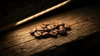 Roasted coffee beans scattered on rustic wooden surface with warm dramatic lighting creating cozy cafe atmosphere for beverage and food concepts.