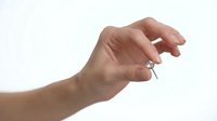 Close-up of a hand holding a small silver key against a white background, symbolizing access, security, solutions, and unlocking opportunities for business and design projects.