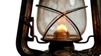 Vintage kerosene lantern with glowing flame isolated on white background, suitable for design projects, merchandise printing, and historical themed graphics.