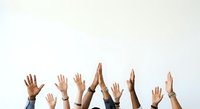 Group of diverse hands raised together in unity, celebration, or teamwork against white background. Represents collaboration, community support, and collective success.