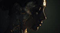 Young African American woman with cracked golden skin effect in dramatic side lighting against dark background for artistic portrait concepts.