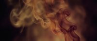 Swirling smoke wisps in warm golden and amber tones rise against a dark background, creating a dramatic, moody atmosphere.