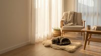 Cozy Scandinavian living room with a tabby cat sleeping on a fluffy rug, armchair with knit blanket, sheer curtains, warm sunlight.