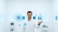 Male doctor in white coat presenting virus molecules in modern medical laboratory for healthcare education and research presentations.