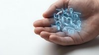 Male hand holding glowing digital hologram of connected smart home devices and IoT technology icons for home automation and wireless connectivity solutions.