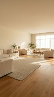Modern minimalist living room with beige furniture, natural light and wooden floors creating warm cozy atmosphere for home interior design.