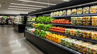 Modern grocery store produce section with fresh vegetables and fruits displayed in refrigerated cases for healthy shopping and retail business.