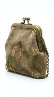 Vintage distressed fabric coin purse with brass clasp and chain strap, isolated on white background. Worn textile accessory for fashion, antique collecting, or retro design projects.