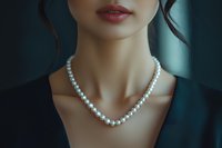 Close up of elegant pearl necklace on woman's neck against dark background, showcasing luxury jewelry and feminine beauty in sophisticated fashion style.