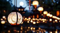 Glowing paper lanterns with delicate floral patterns create magical atmosphere at dusk, illuminating outdoor space with warm light and traditional Asian decorative elements.