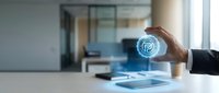 Businessman holding glowing fingerprint icon above tablet, representing digital security, biometric authentication, and cybersecurity technology solutions for business.