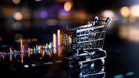 Shopping cart on financial chart background with colorful bokeh lights reflecting market trends and retail consumer behavior analysis.