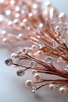 Delicate rose gold branches adorned with sparkling crystals and pearls create an elegant decorative arrangement against soft white background. For wedding design.