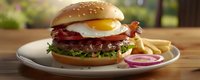 Juicy beef burger topped with crispy bacon, sunny side up egg, fresh lettuce on sesame bun served with french fries and red onion rings on white plate.