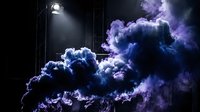Dramatic purple and blue smoke clouds illuminated by stage lighting in dark atmospheric setting for theatrical productions and creative projects.