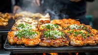 Juicy grilled chicken thighs with fresh herbs and spices on black grill pan, steam rising. Close up view of marinated meat with crispy skin and garnish.