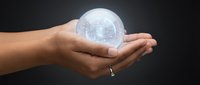 Young adult with medium skin tone holding illuminated globe in cupped hands against dark background, symbolizing global responsibility, sustainability, and environmental care for business and eco concepts.