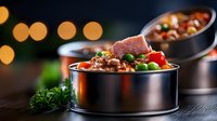 Fresh beef stew with tender meat, colorful vegetables and herbs served in individual metal containers against dark background with bokeh lights.