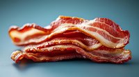 Crispy cooked bacon strips with golden brown edges and marbled fat layers on clean background for culinary and breakfast food concepts.