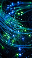 Fiber optic cables with glowing blue and green lights over circuit board representing high-speed internet connectivity and data transmission technology.