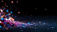 Vibrant glitter explosion with pink and blue particles scattered on dark background, creating magical sparkle effect with bokeh lights and dynamic motion blur.