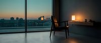 Modern minimalist interior with floor-to-ceiling windows overlooking city skyline at dusk, featuring sleek chair and desk with warm lamp lighting for contemporary office or residential design projects.