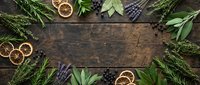 Fresh herbs and dried citrus slices arranged on rustic wooden background with copy space. Natural cooking ingredients frame for culinary recipes and food preparation.