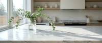 Modern kitchen interior with fresh eucalyptus branches in glass vase on marble countertop. Bright natural light creates peaceful cooking space atmosphere.