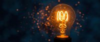 Glowing vintage filament lightbulb with warm orange light and bokeh particles on dark blue background, symbolizing innovation, creativity, and ideas for design projects.