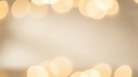 Soft golden bokeh lights creating warm ambient glow on blurred cream background for holiday celebrations, romantic events, and festive decorations.