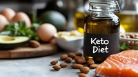 Fresh salmon fillet with healthy fats from avocado, almonds, olive oil and eggs on wooden cutting board, selective focus on glass jar with text.